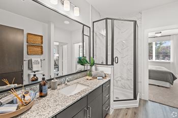 A bathroom with a sink, mirror, and shower.